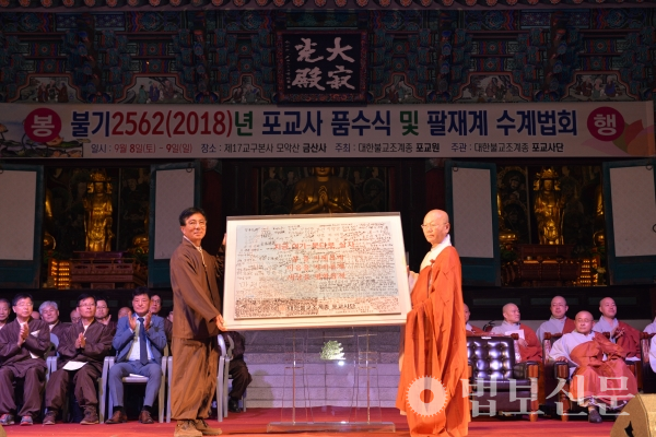 신행혁신 깃발을 주고 받는 윤기중 포교사단장과 포교원장 지홍 스님.