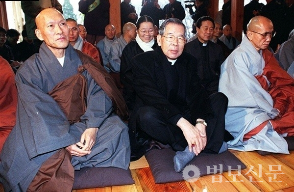 서울 길상사 개원법회에서 나란히 바닥에 앉아 있는 법정 스님과 김수환 추기경.