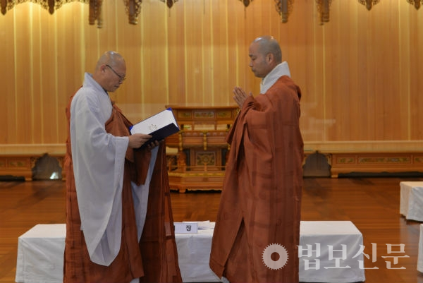 선운사 주지후보로 재선출된 현 주지 경우 스님이 중앙선관위원 선우 스님으로부터 당선증을 받고 있다.