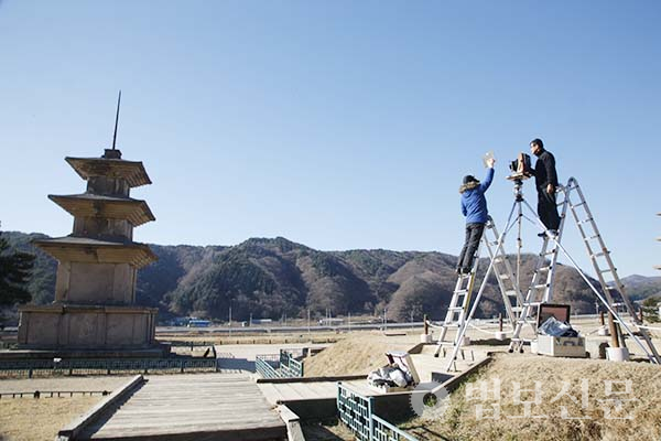 양현모 작가가 사다리에 올라 ‘경주 감은사지 삼층석탑’을 촬영하는 모습. 이 촬영을 계기로 석탑에 매료돼 전국의 탑들을 카메라에 담기 시작했다.