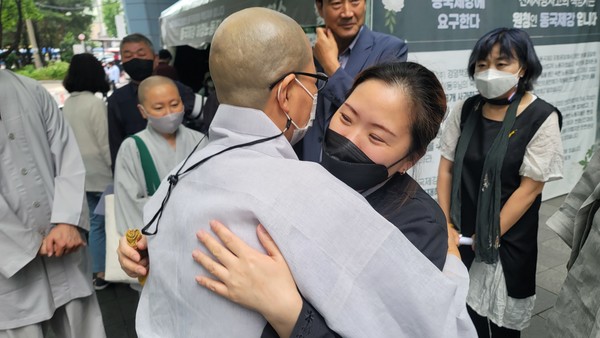고 이동우 동국제강 노동자 아내 권금희씨가 사회노동위 스님들과 포옹하고 있다.