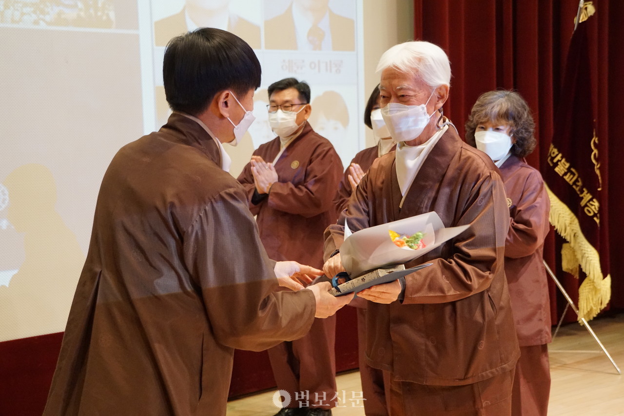 이기룡 포교사가 올해 3월6일 서울 한국불교역사문화기념관에서 열린 ‘포교사단 출범 22주년 및 제9회 포교사의날 기념범회 시상식’에서  김영석 단장에게 특별공로상을 받고 있다.