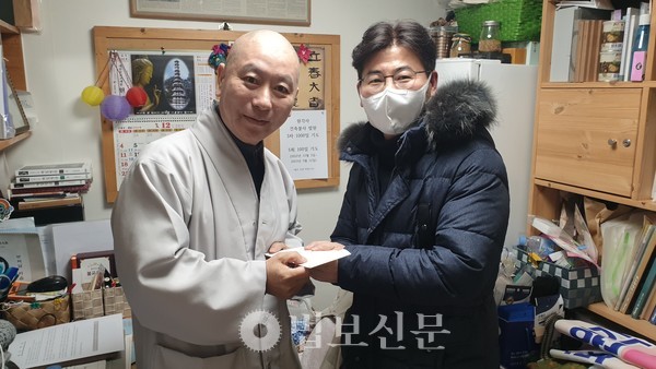 법보신문 편집국 권오영 부장이 사회복지원각 대표 원경 스님에게 후원금을 전달하고 있다.