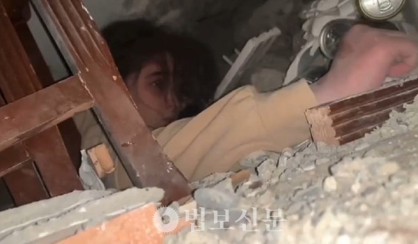 건물 잔해에 깔려있는 튀르키에 소녀.