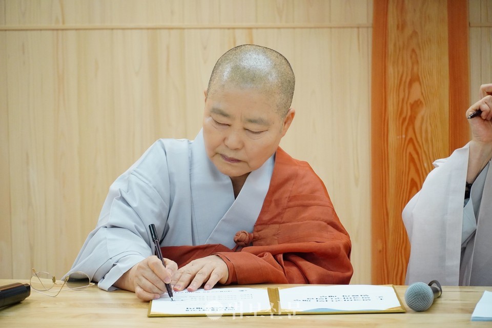 인수인계서에 서명하는 12대 비구니회장 본각 스님.
