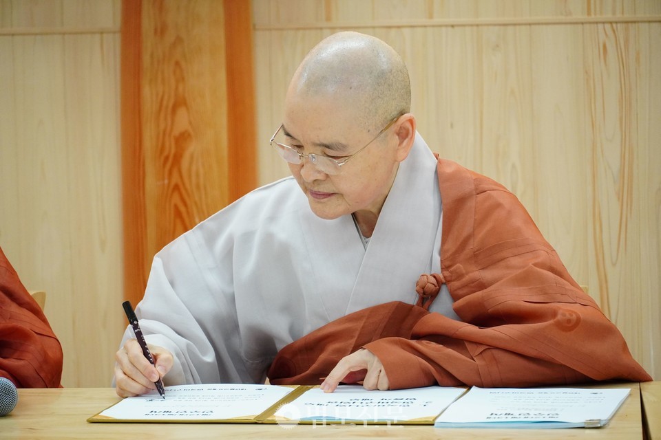 인수인계서에 서명하는 13대 비구니회장 광용 스님.