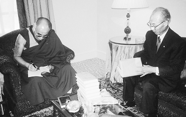 달라이라마가 이상규 변호사에게 선물할 책에 서명을 하고 있는 모습.