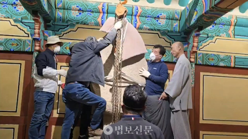 3월 25일 문화유산 보존 관계자들이 고운사 주지 등운 스님이 참관한 가운데 보물 ‘의성 고운사 석조여래좌상’의 광배를 옮기고 있다.[사진=김윤기]