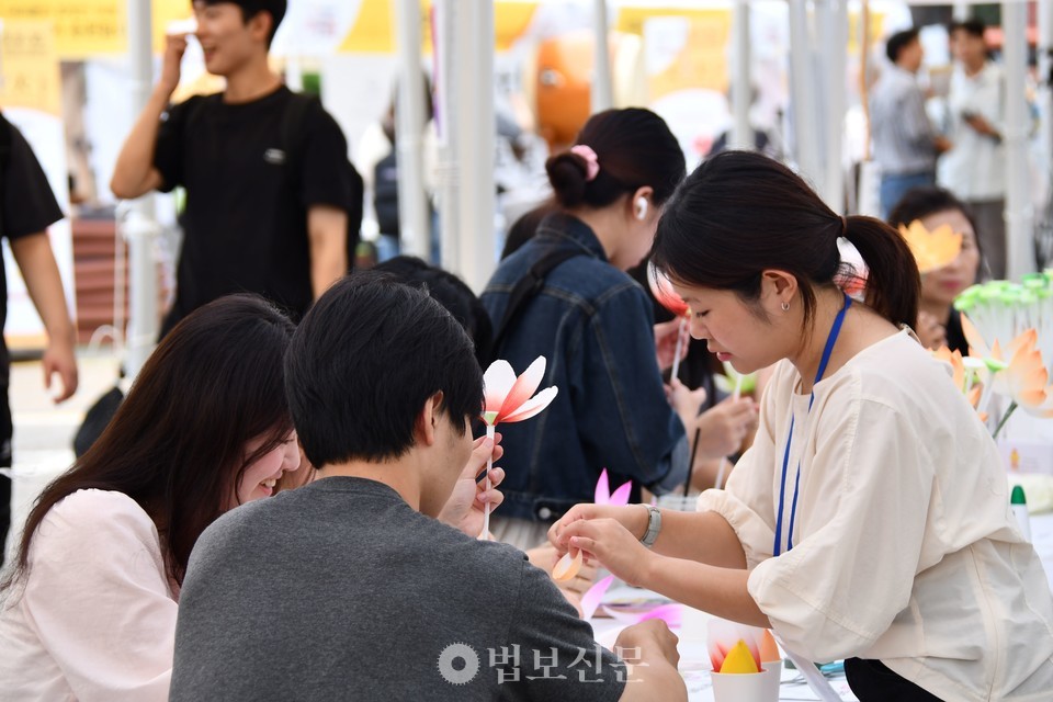 동국대 학생들이 2025 불교문화대전에서 연꽃 만들기를 체험하고 있다.