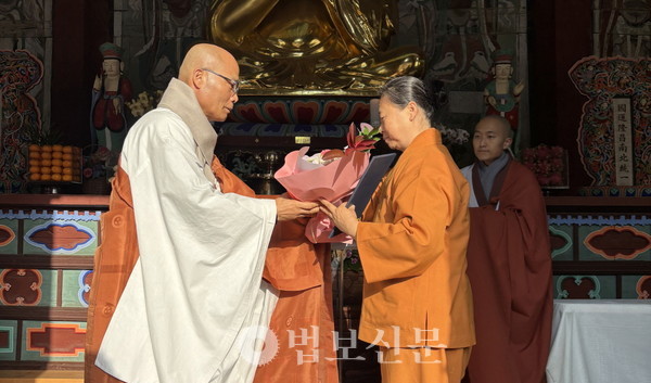 선운사 단기출가학교장 경우 스님이 수료생에게 수료증과 꽃다발을 전달하고 있다. [선운사 제공]