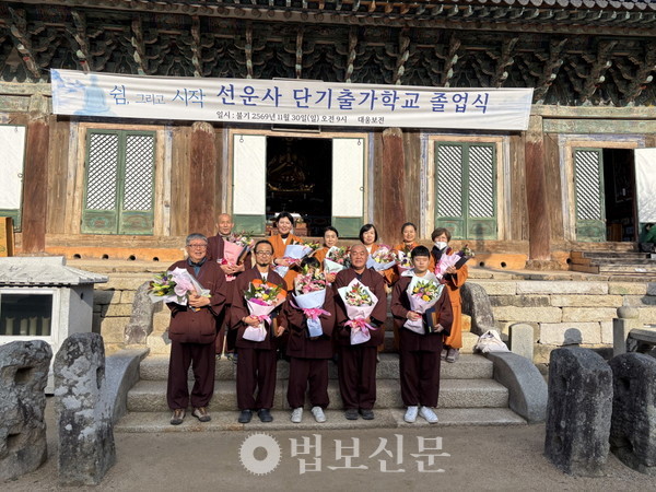 9박 10일 과정을 마친 단기출가학교 수료생들이 대웅보전 앞에서 꽃다발을 들고 기념촬영을 하고 있다.